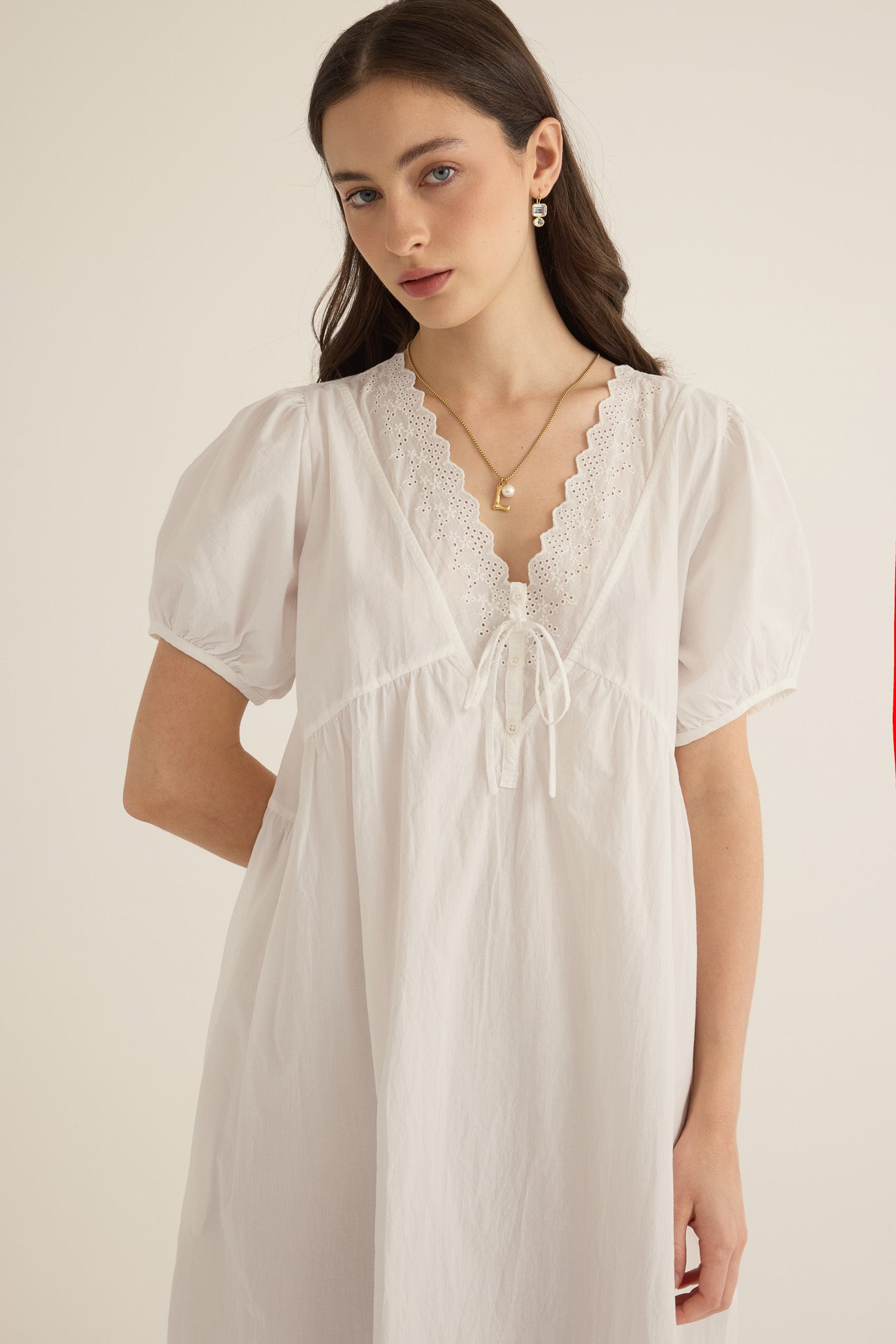 Front closeup view of model wearing the Amelie organic cotton v-lace midi dress in ivory