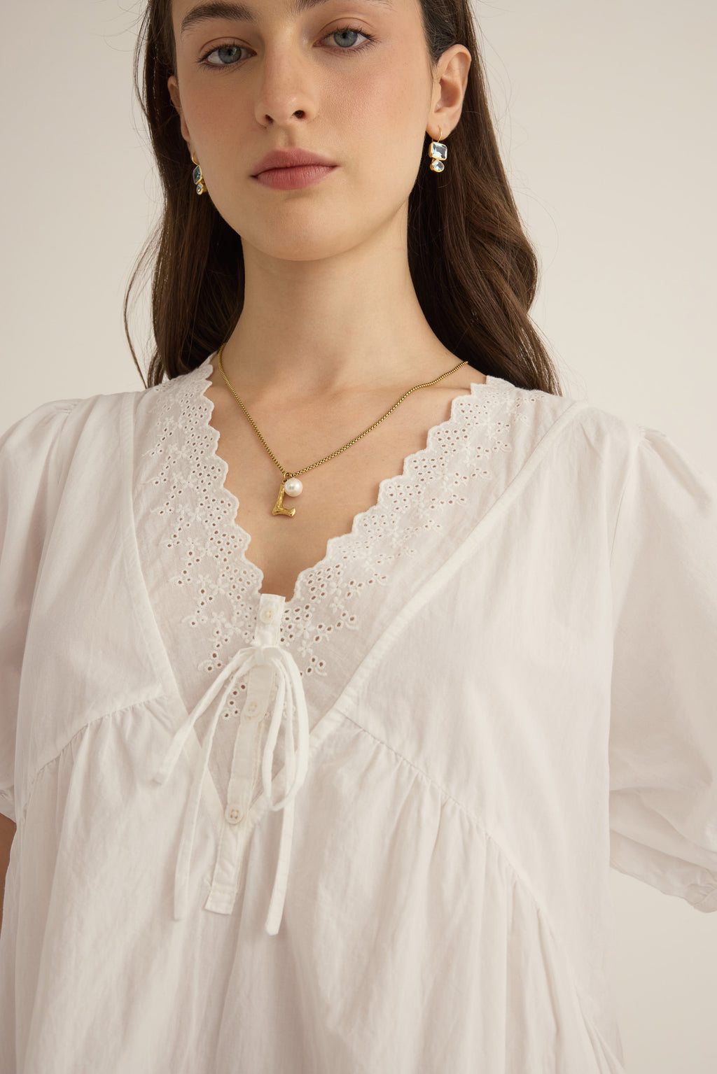 Front closeup detail of lace on model wearing the Amelie organic cotton v-lace midi dress in ivory