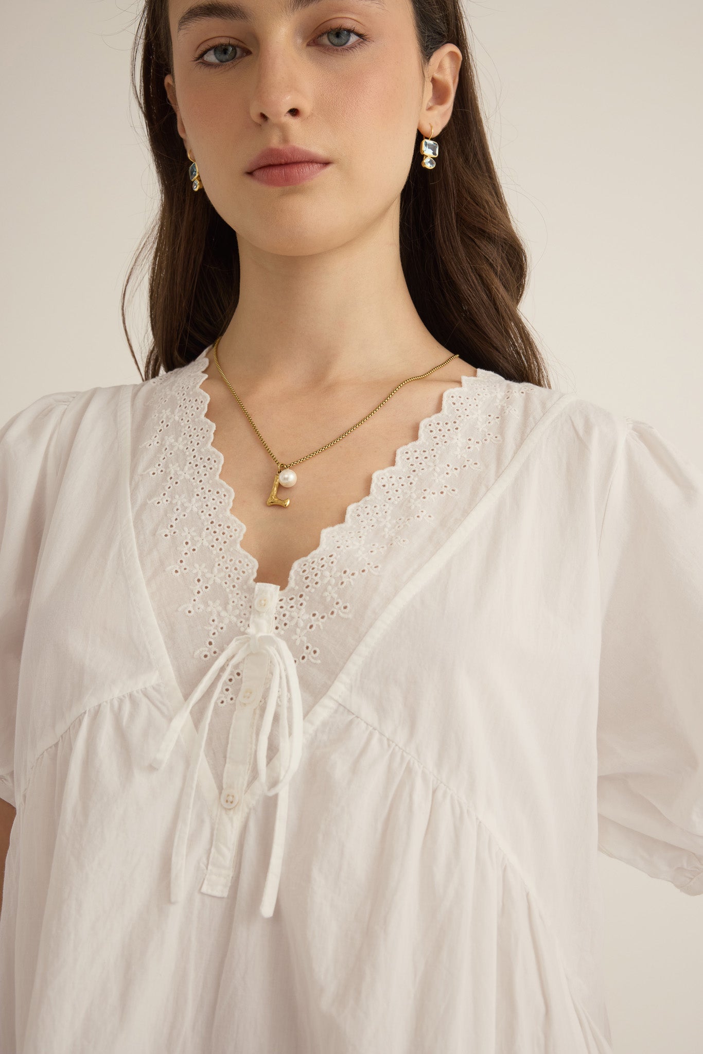 Front closeup detail of lace on model wearing the Amelie organic cotton v-lace midi dress in ivory