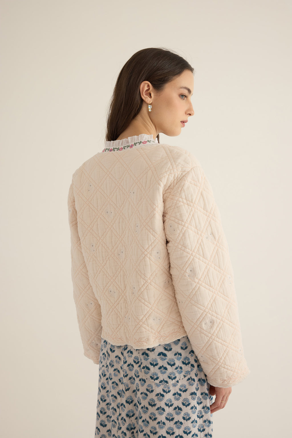 Side closeup view of model wearing the Anais Organic Cotton Quilted Jacket with Ties in rosewater pale pink