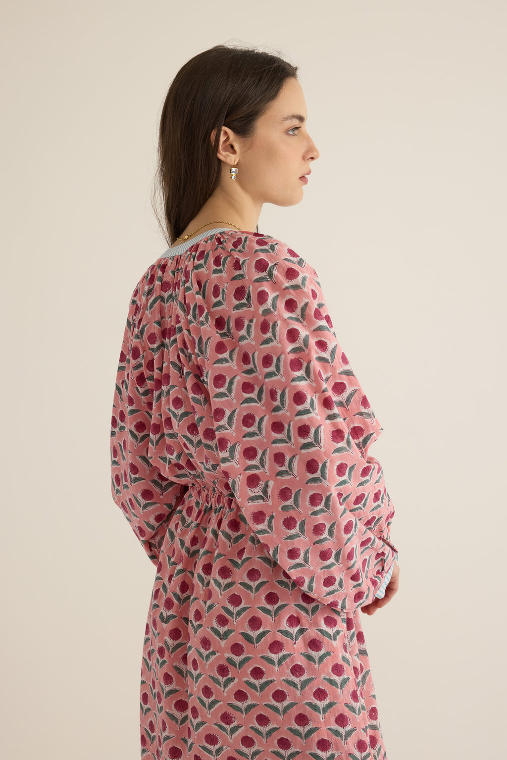 Side view of model wearing the Juliet Block Printed Cotton Drop Sleeve Raglan Shirt Dress in Pink Dahlia, showing the billowing sleeve