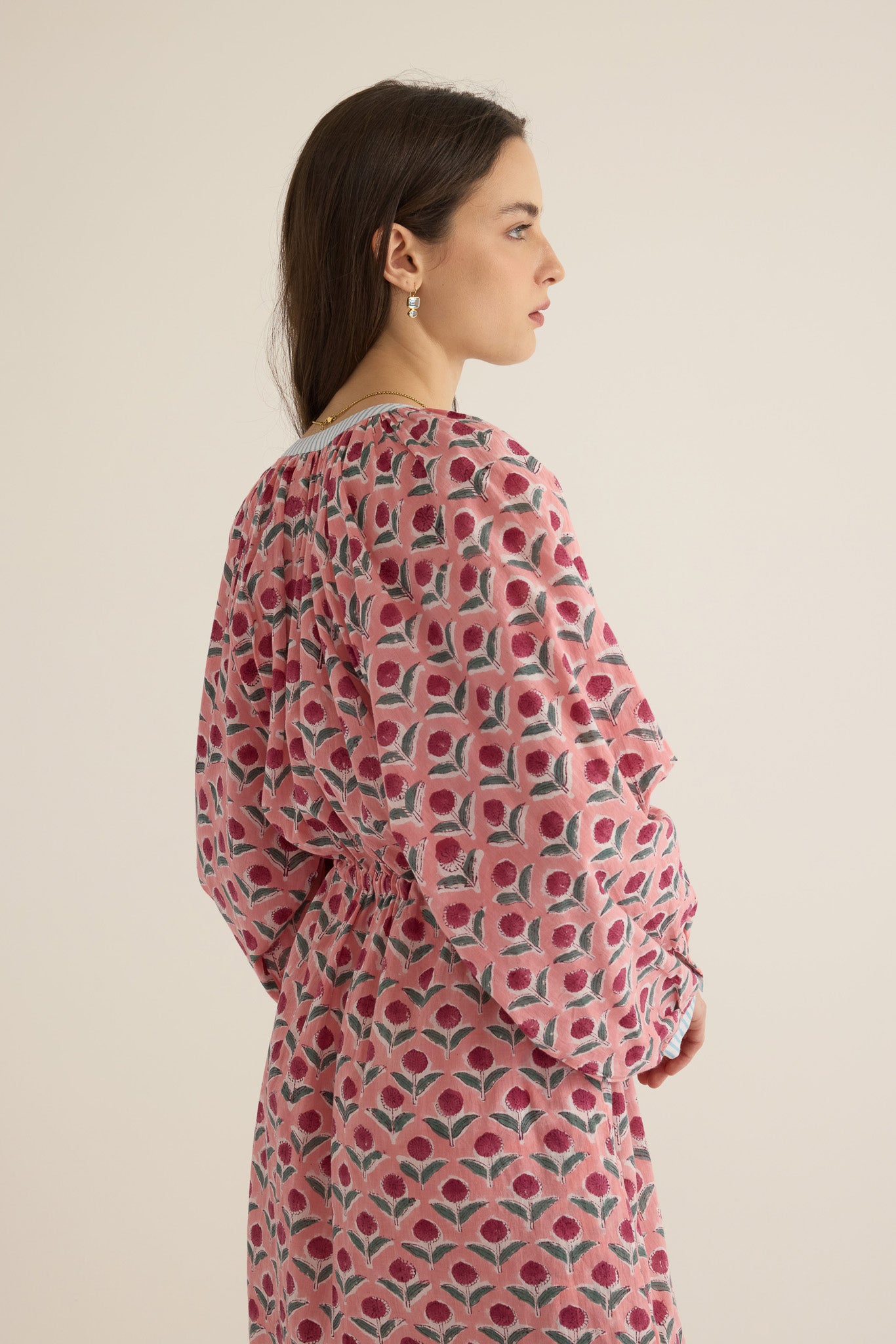 Side view of model wearing the Juliet Block Printed Cotton Drop Sleeve Raglan Shirt Dress in Pink Dahlia, showing the billowing sleeve