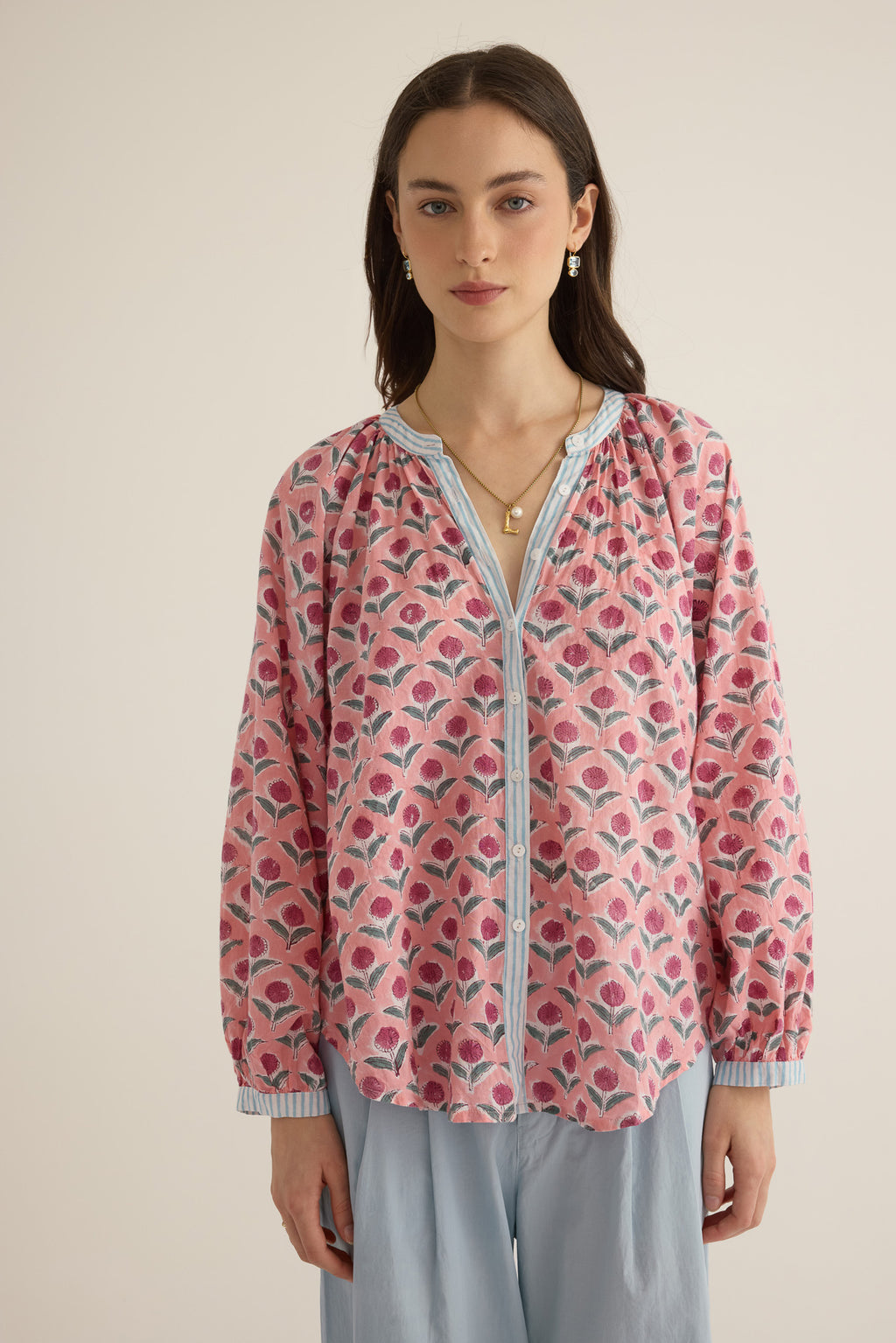 Front closeup view of model wearing the Juliet Block Printed Cotton Drop Sleeve Raglan Shirt in Pink Dahlia, with arms looks and shirt untucked