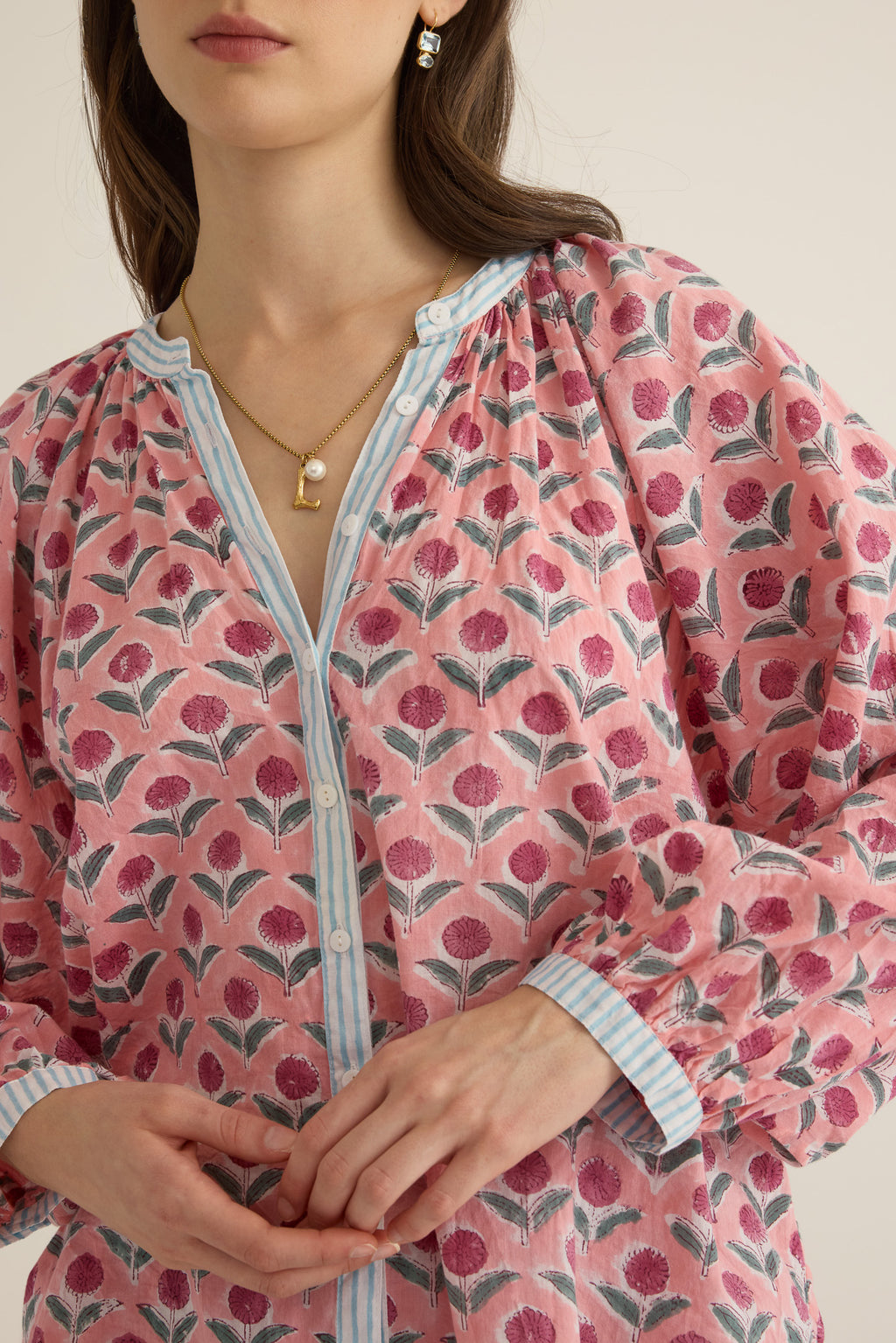 Closeup view of model wearing the Juliet Block Printed Cotton Drop Sleeve Raglan Shirt in Pink Dahlia, showing buttoned front and contrast stripe print on placket and cuffs