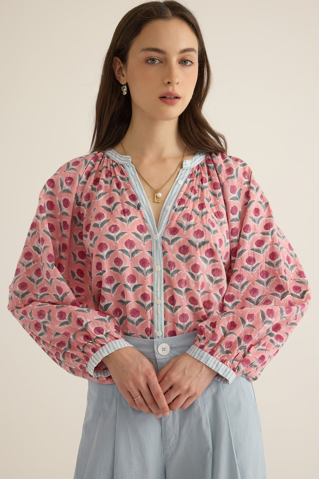 Front view of model wearing the Juliet Block Printed Cotton Drop Sleeve Raglan Shirt in Pink Dahlia, with hands folded at her waist