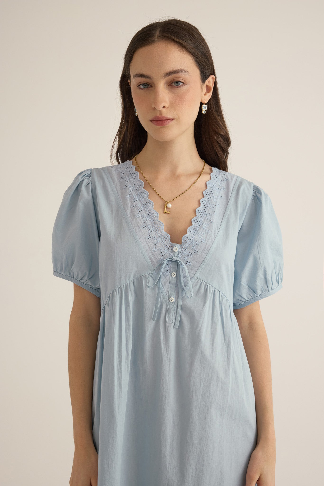 Close front view of model wearing the Amelie organic cotton v-lace midi dress in forget me not pale blue.