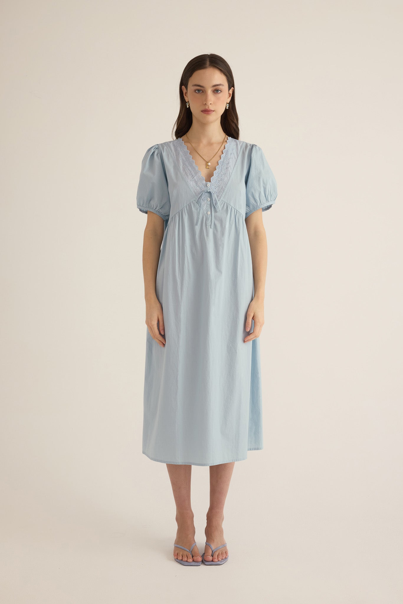 Model wears the Amelie organic cotton v-lace midi dress in forget me not pale blue