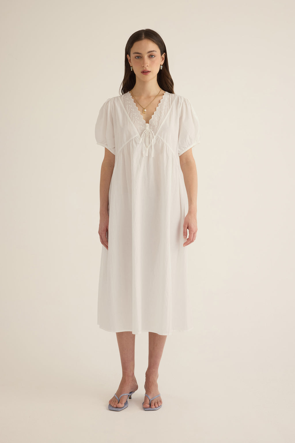 Front view of model wearing the Amelie organic cotton v-lace midi dress in ivory