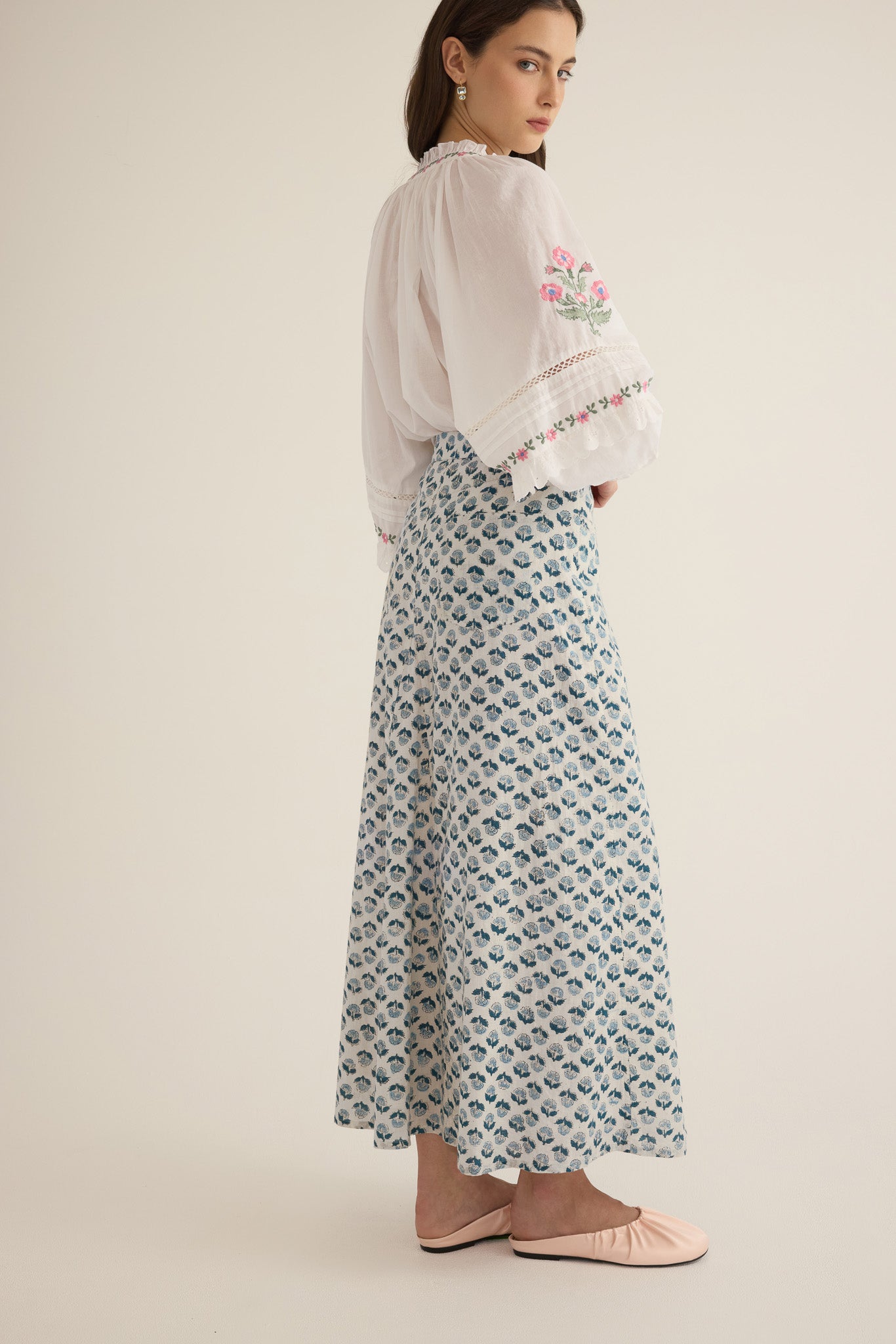 Side view of model wearing the Joni Block Printed Cotton A-Line Midi Skirt in Blue Gardenia with the Juliet Embroidered Raglan Drop Sleeve Blouse in Ivory
