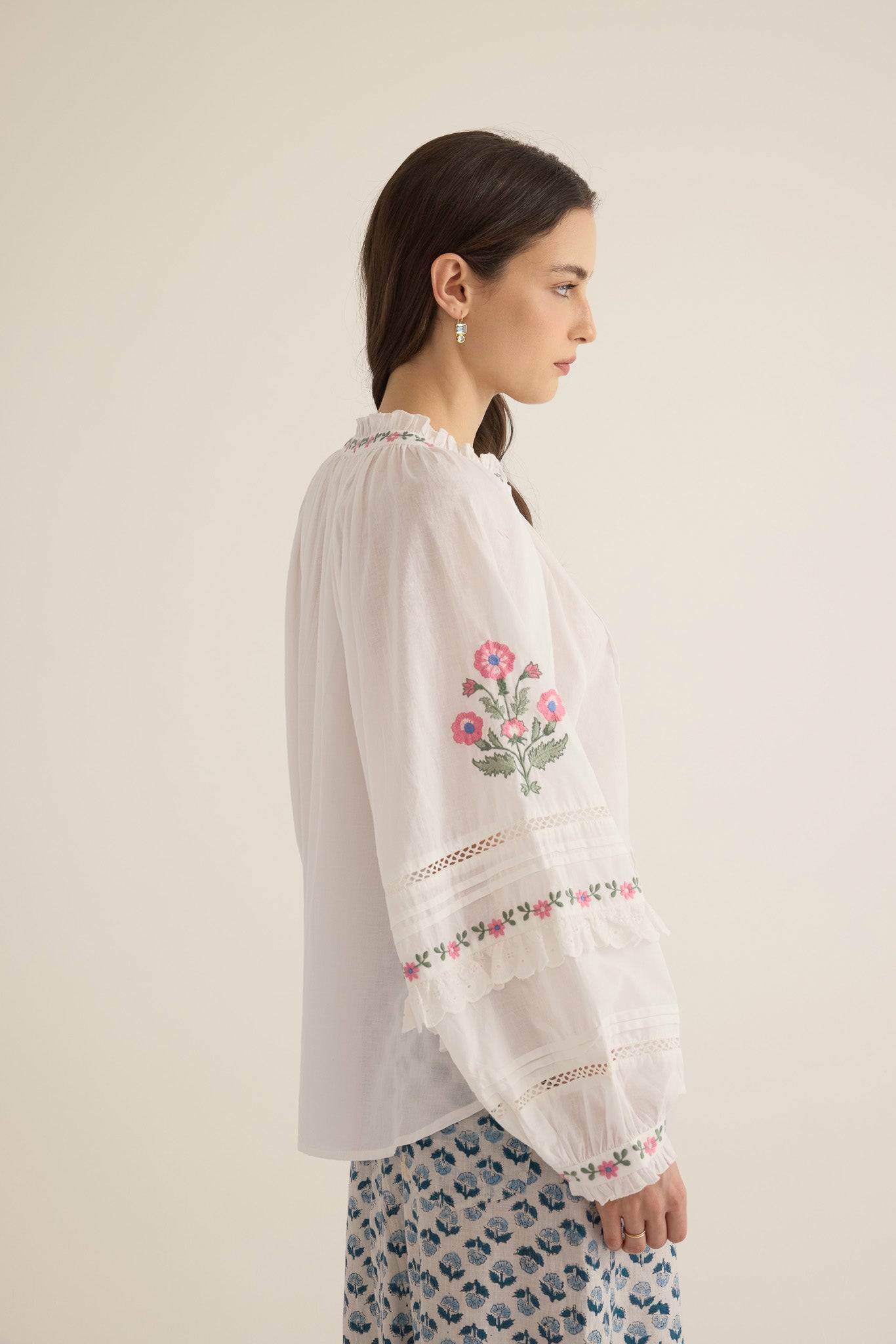 Side sleeve view of model wearing the Juliet Embroidered Cotton Juliet Drop Sleeve Raglan Shirt in Ivory with floral embroidered motifs, pintucking and lace detail