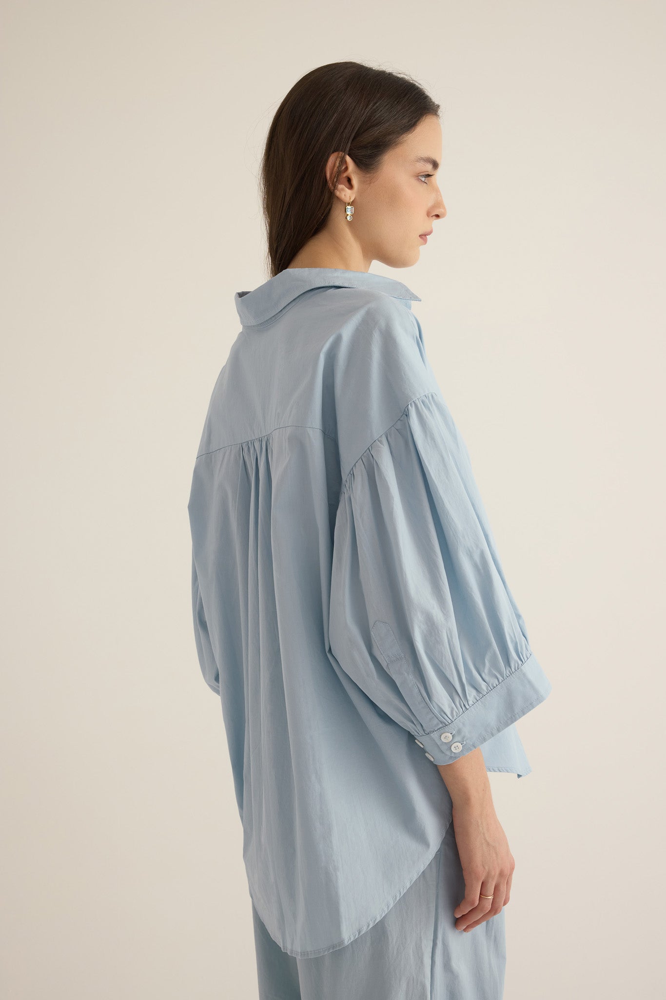 Close up of model wearing the Romeo wide cuff shirt and pleated pant in forget me not pale blue
