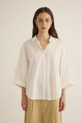 Model wearing the Romeo wide cuff shirt in ivory organic cotton, styled with the Romeo wide leg pleat pant in taos taupe beige