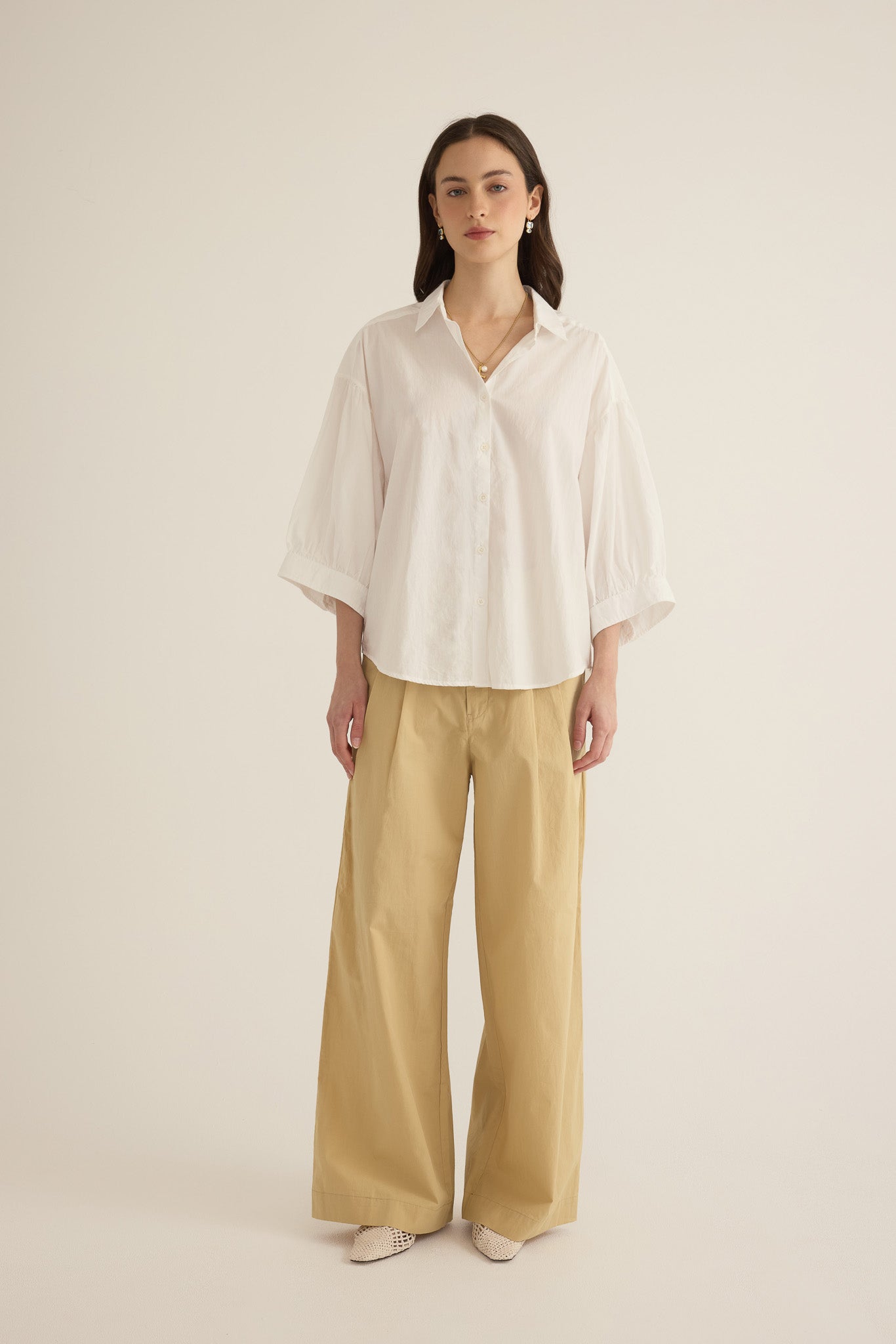 Model wearing the Romeo wide cuff shirt in ivory organic cotton, styled with the Romeo wide leg pleat pant in taos taupe beige