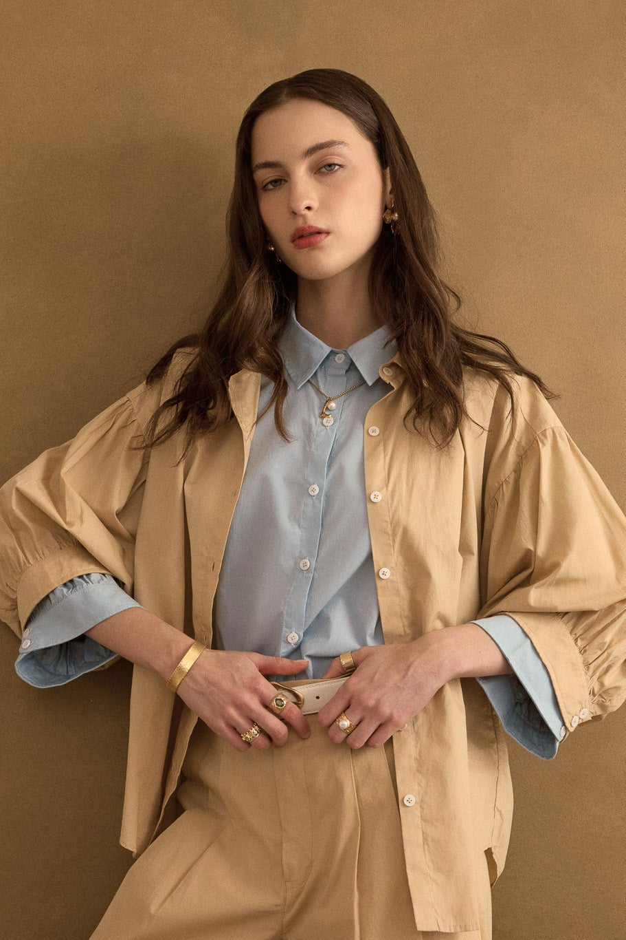 Close up of model wearing the Romeo wide cuff shirt in taos taupe beige over forget-me-not blue