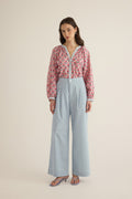 Model wearing the Romeo wide-leg pleat pant in pale blue organic cotton, styled with the Juliet block print pink and blue patterned shirt